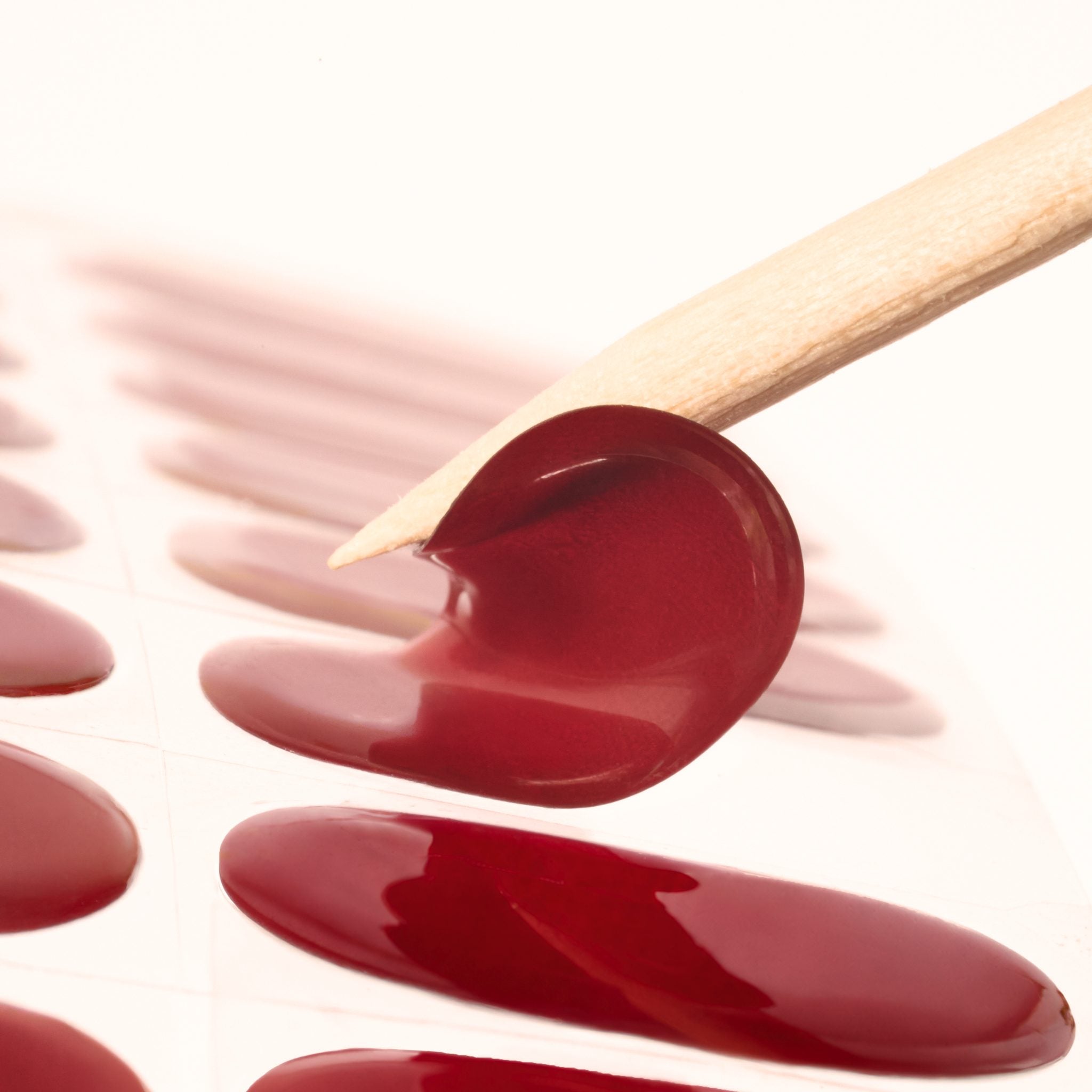 Close-up of a Muted Burgundy GEWEL™ semi-cured gel nail sticker peeled with a wooden stick