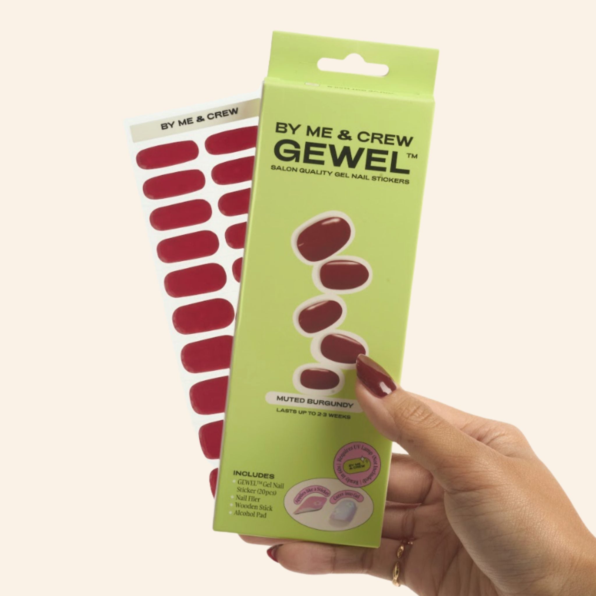 Hand holding Muted Burgundy GEWEL™ box and nail sticker sheet by By Me & Crew